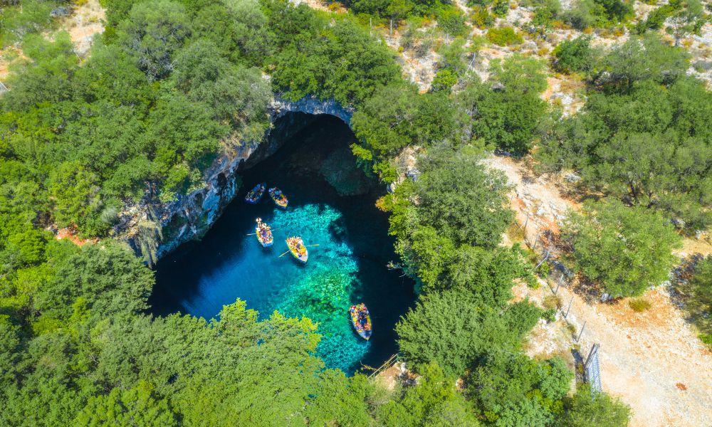 5. Melissani Cave & Lake
The Melissani Cave and Lake is a truly magical place and one of the top attractions on Kefalonia you won't want to miss. This fascinating place has a hole at the roof of the cave, which creates a shimmering blue light, giving the lake a surreal and picturesque look. You can take a boat ride into the cave to get up close and personal with this amazing sight. 
And if you want to be truly blown away by nature's beauty, I suggest visiting this cave and lake during sunset or sunrise. The pictures you take will certainly be worth it. I strongly recommend that you wear sturdy footwear and take lots of water with you.
