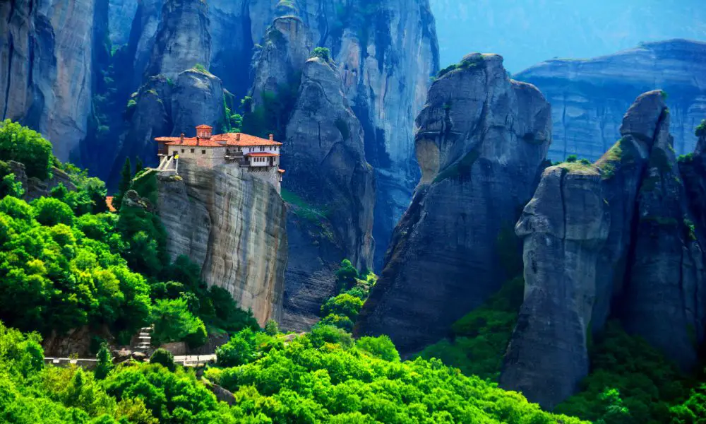 6. Monastery of Rousanou
Next on my list of the top attractions at the Meteora Monasteries is the Monastery of Rousanou. It's one of the loveliest monasteries in Meteora, perched on top of an enormous pillar. The views across the Meteora rock formations are truly memorable.
This monastery was built in 1288 and is dedicated to Saint Barbara. In 1988, it was converted to a convent and is occupied by nuns who are still actively involved in the church's activities. You can take part in services here, which is an amazing experience.
Inside, you will find beautifully painted walls and a large collection of Byzantine holy items. There's a lovely little garden in the courtyard that is the perfect place to relax and enjoy the views.
