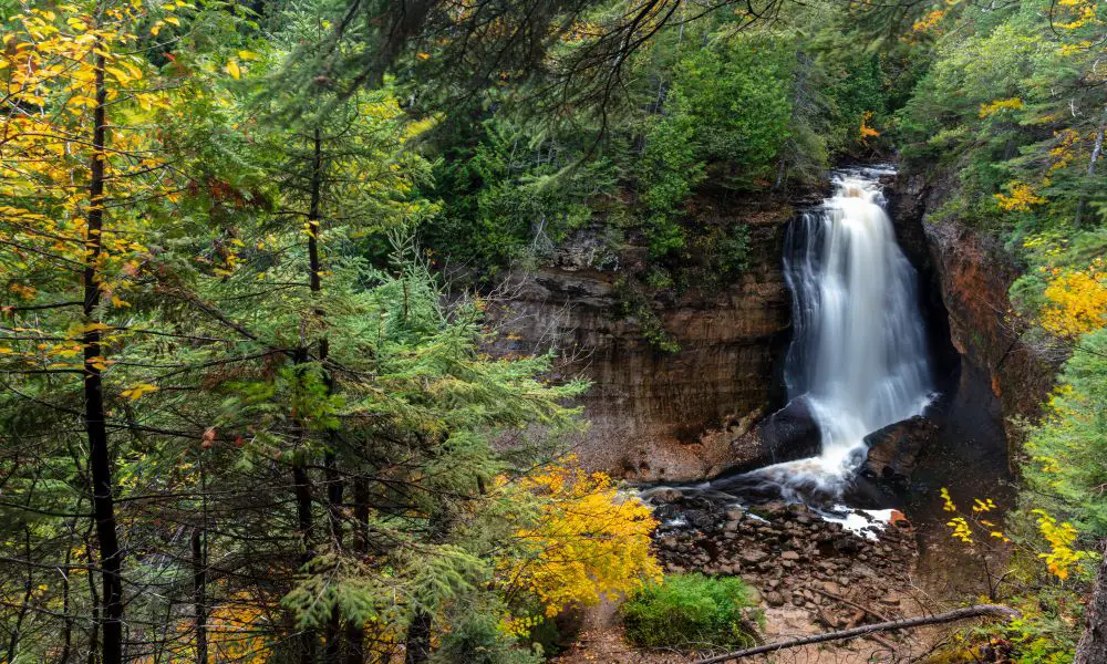 9. Miners Falls
Miners Falls is another one of the best waterfalls in Michigan that you can find in the Upper Peninsula. It's located in the town of Munising, a great place to visit if you're looking to explore the Pictured Rocks National Lakeshore.
Miners Falls is a small but beautiful waterfall with a drop of only 40 feet. But what it lacks in height, it makes up for in views. The falls flow over a series of sandstone ledges that have been carved out by years of erosion. And the surrounding forest has a peaceful, tranquil atmosphere that makes it the perfect place to relax and take in the natural beauty.
To get to Miners Falls, you'll have to take a short hike. The trailhead starts at the Miners Falls Scenic Area Parking Lot. From there, it's about a half-mile hike to the falls. The trail is well-marked and relatively easy to follow.
